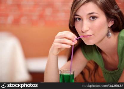 Woman drinking green cocktail