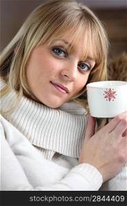 Woman drinking hot beverage to warm herself up