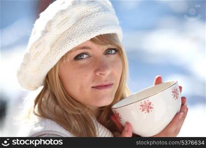 Woman drinking hot mug of coffee on a winters day