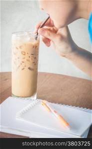 Woman drinking iced milk coffee, stock photo