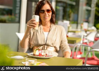 Woman drinking latte at cafe bar dessert cheesecake restaurant terrace