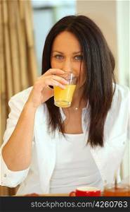 Woman drinking orange juice at breakfast