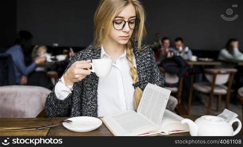 woman drinking reading book