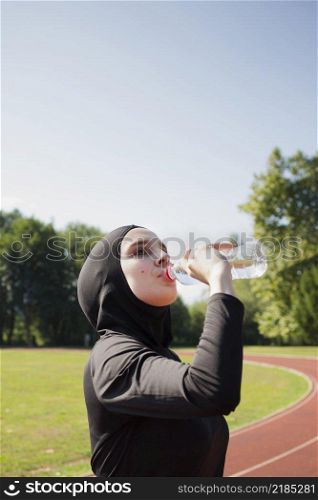 woman drinking water from plastic bottle