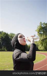 woman drinking water from plastic bottle
