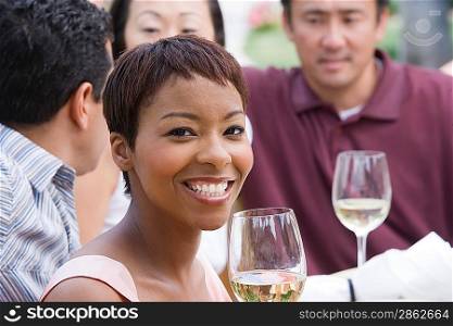 Woman drinking wine with friends outdoors