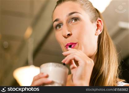 Woman drinking with a straw a drink - it is a milkshake