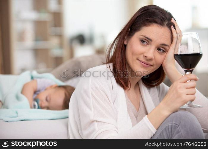 woman drinks wine while baby sleeps