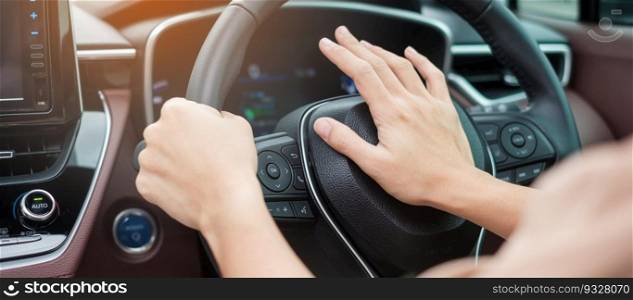 woman driver honking a car during driving on traffic road, hand controlling steering wheel in vehicle. Journey, trip and safety Transportation concepts