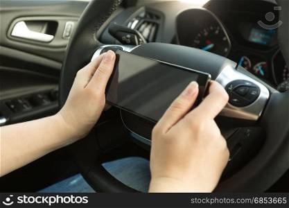 Woman driving a car and typing message on phone