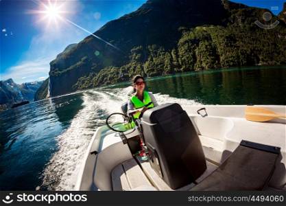 Woman driving a motor boat. Geiranger fjord, Beautiful Nature Norway.Summer vacation.