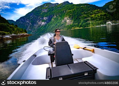 Woman driving a motor boat. Geiranger fjord, Beautiful Nature Norway.Summer vacation.