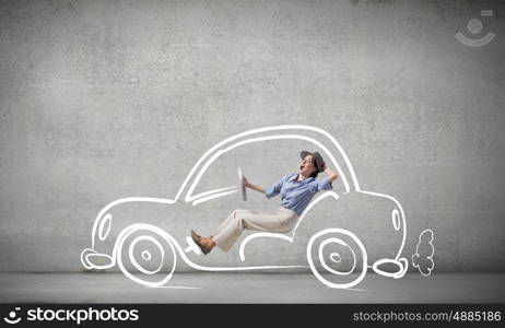 Woman driving old styled drawn car. Young humorous woman driving drawn funny car