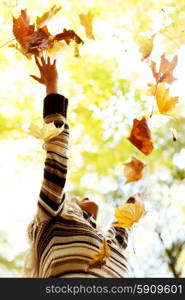 Woman drop up autumn leaves. Happy young woman drop up autumn leaves