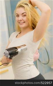 Woman drying wet armpit using hair dryer. Getting rid of sweat and bad smell, hyperhidrosis.. Woman drying sweat stains using hair dryer