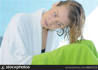 woman drys hairs with towel