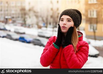 Woman during winter snowy day warming up her cold hands. Weather conditions, forecasting concept.. Woman during winter warming up her hands
