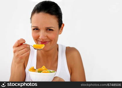 Woman eating a bowl of fruit