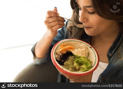 Woman eating a vegan bowl of superfoods