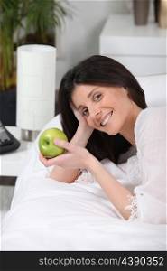 Woman eating an apple on her coach