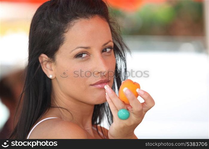 Woman eating an apricot