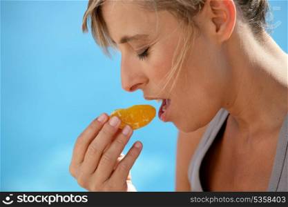 Woman eating an orange segment