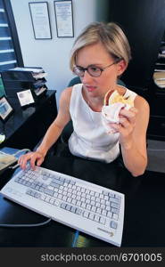 woman eating at computer keyboard
