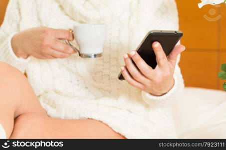 Woman eating breakfast in bed while looking at your mobile phone