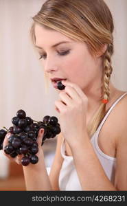 Woman eating bunch of grapes
