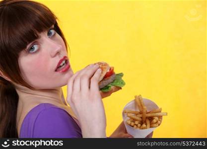 Woman eating burger and chips