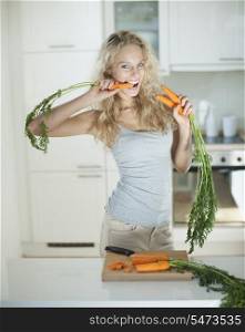 Woman eating carrot at kitchen counter