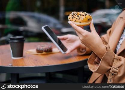 woman eating donuts and looking at phone