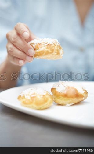 Woman eating eclairs at home. Vertical photos