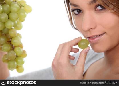 Woman eating green grapes