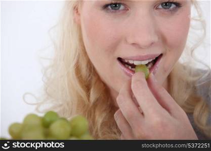 Woman eating green grapes
