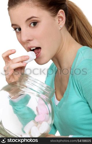 Woman eating marshmallows from jar