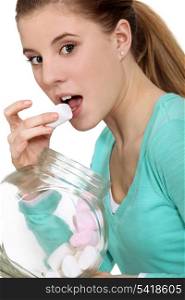 Woman eating marshmallows from jar