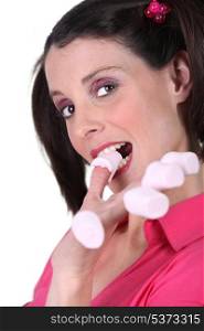 Woman eating marshmallows off her fingers