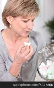 Woman eating marshmallows straight out of a jar