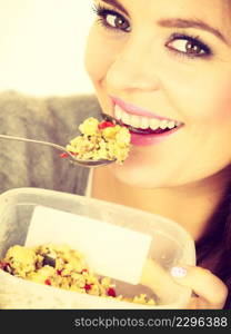 Woman eating oatmeal with nuts and dried fruits for breakfast. Girl holds plastic container take homemade lunch with healthy eating. Dieting nutrition concept. Woman eat oatmeal with dry fruits. Dieting