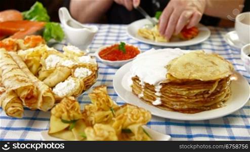 Woman eating pancakes at the table on the Pancake Day