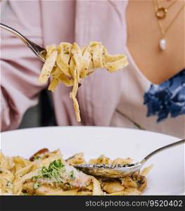 Woman Eating pasta with Mushrooms on wood table