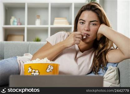 woman eating popcorn while looking laptop 2