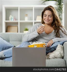 woman eating popcorn while looking laptop 3