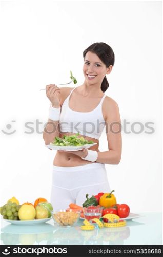 Woman eating salad leaves