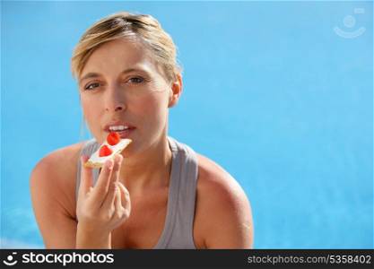 Woman eating toast with slices of strawberry