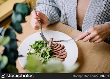 Woman eats Vitello Tonnato in restaurant
