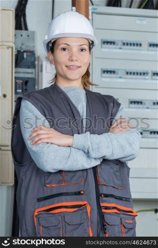 woman electrician posing next to the panel
