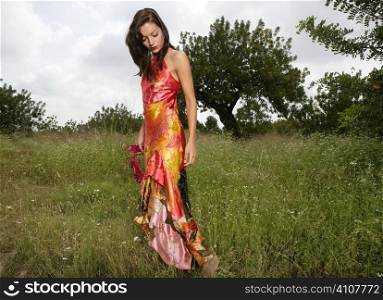 woman elegant, with red dress haute couture, on the forest outdoors
