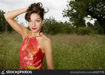 woman elegant, with red dress haute couture, on the forest outdoors